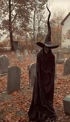 a man dressed as a witch in a graveyard