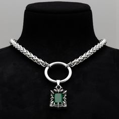 Unleash your inner spirit with the Emerald Claw Pendant Choker necklace. This striking piece features a captivating emerald green stone, ensnared by a silver claw, suspended from a robust 34mm stainless steel O Ring. The silver toned stainless steel foxtail chain enhances its gothic allure, offering both style and strength. Available in three sizes with a 4-inch adjuster chain, it ensures a perfect fit for every neckline. Each choker arrives nestled in a velvet pouch, ready to make a statement o Choker Necklace Silver, Emerald Green Stone, O Ring Choker, Gothic Bracelet, Word Necklace, Gothic Pendant, Pendant Choker Necklace, Gothic Chokers, Gothic Earrings