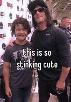 a man standing next to a little boy in front of a red carpet with the words, this is so stinking cute