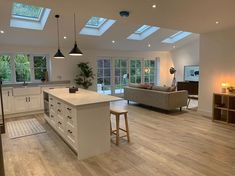 an open kitchen and living room with skylights