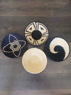 four black and white baskets sitting on top of a wooden floor