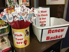 there is a bucket full of stickers on the desk next to books and magazines