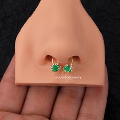 a pair of green earrings sitting on top of a fake dummy