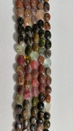 multicolored stones are arranged on a white surface