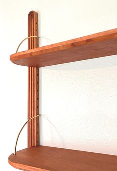 a wooden shelf with two metal rods attached to it