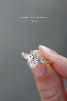 a person holding a diamond ring in their hand with the words harmony jewels on it