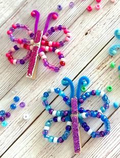 three colorful hair clips sitting on top of a wooden table next to beaded beads