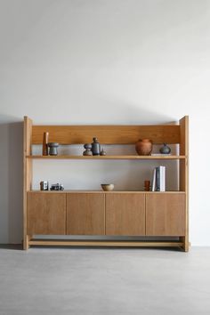 a wooden shelf with bowls and cups on it