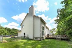 a white house sitting on top of a lush green field