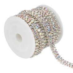 a spool of white and silver colored crystal beaded ribbon on a white background