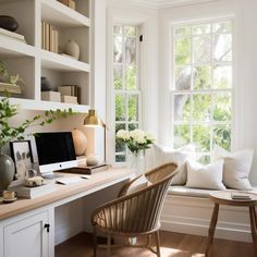 a home office with white walls and wooden flooring, built - in shelving units