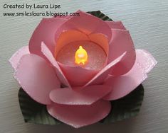 a pink flower with a lit candle in it