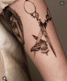 a woman's arm with a tattoo on it and a knife in the middle