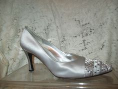 Stunning silver evening pumps. Size 7 1/2. Fabric uppers. Leather lining and sole.  3 1/4" covered heel.  The toes are embroidered in a geometric design in pewter, silver and white with sparkly square rhinestones. They have been worn once or twice and have a few light surface scuffs. Light sole wear. The inside heel area shows some darkening also the foot bead shows some wear.  I ship same or next business day. Fitted Silver Wedding Shoes With 4-inch Heel, Metallic Silver Pointed Toe Heels For Wedding, Fitted Silver Heels With Almond Toe, Silver Closed Toe Wedding Shoes For Evening, Silver Wedding Shoes With 4-inch Heel, Silver Almond Toe Wedding Shoes For Evening, Gray Fitted Heels For Evening, Fitted Gray Heels For Evening, Silver Glamorous Wedding Shoes