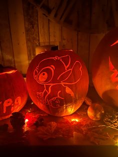 three carved pumpkins sitting on top of a table next to each other with faces drawn on them