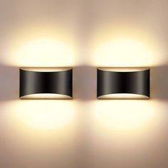 two lights are on the wall next to each other, one is black and the other is white