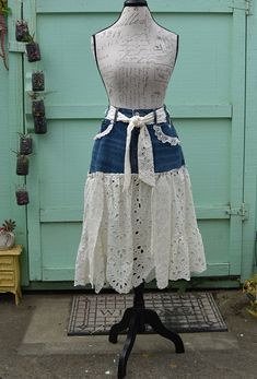 a mannequin wearing a white top and blue denim skirt with lace trims