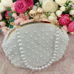 This luxurious encrusted pearl bridal clutch never fails to turn heads with its understated elegance and classic design. Adorned with varying sized White pearls and enhanced with a large creamy pearl clasp, this bridal clutch is the very picture of refinement. This elegant bridal clutch features rose gold trim, attachable chain and large enough for your phone. Complete your list of must-have wedding accessories with the ultimate bridal accessory to finish off your look and storing your wedding d Wedding Embellished Pearl Evening Bag, Formal Bridal Accessories In Pearl White, Handheld Beaded Evening Bag For Wedding, Handheld Evening Bag With Pearl Embroidery For Wedding, Handheld Pearl Bag For Wedding, Pearl White Handheld Evening Bag, Handheld Pearl Embroidered Evening Bag For Weddings, Handheld Pearl Embroidery Evening Bag For Wedding, Pearl White Evening Bag With Pearl Handle For Wedding