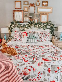 a bedroom decorated for christmas with red and white bedding, framed pictures on the wall