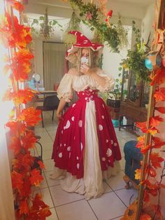 a woman in a red and white dress taking a selfie with her cell phone