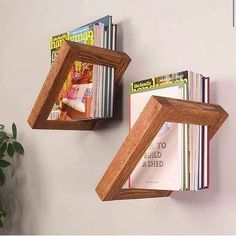 two wooden bookshelves mounted to the side of a wall with magazines on them