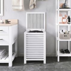 a bathroom with a white cabinet and shelf next to the sink, toilet and towel rack