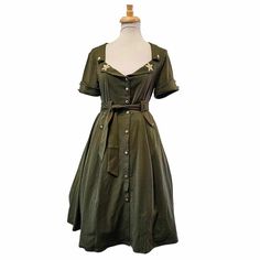 This military green dress embodies a robust and utilitarian aesthetic. It is characterized by its earthy, olive-toned color, reminiscent of camouflage patterns. The dress features gold buttons down the front and on the sleeves, with a star on each lapel. It's a versatile dress, and while it exudes a sense of toughness, it also adds a touch of elegance, making it suitable for various occasions, from casual outings to more formal events!!Size M-4XSEE SIZE CHART FOR SIZING Military Green Dress, Utilitarian Aesthetic, Camouflage Patterns, Versatile Dress, Versatile Dresses, Gold Buttons, The Seven, Military Green, Formal Event