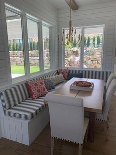 a dining room table and bench in front of windows