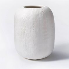 a white vase sitting on top of a table