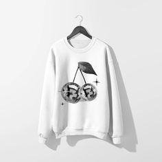 Get groovy in our Disco Cherries White Sweatshirt. Featuring sparkly Y2K vibes, this trendy sweatshirt will elevate your style game. Perfect for adding a touch of whimsy to your everyday look. (Disco ball not included!). This sweatshirt features a bound ribbed neckband, ribbed sleeve cuffs and hemband, and raglan sleev Trendy Graphic Print Sweatshirt For Winter, Trendy Streetwear Sweater, Trendy Relaxed Fit Sweatshirt, Trendy Winter Graphic Tops, Trendy Fall Sweatshirt With Screen Print, Trendy Graphic Print Sweatshirt For Fall, Trendy Fall Graphic Sweatshirt, Trendy Winter Graphic Sweatshirt, Trendy Relaxed Fit Sweatshirt With Screen Print