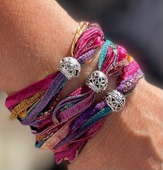 a woman's arm with several bracelets on it