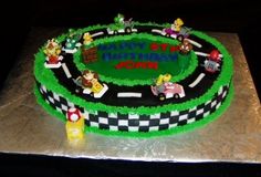 a birthday cake is decorated with mario and luigi's race track, including cars