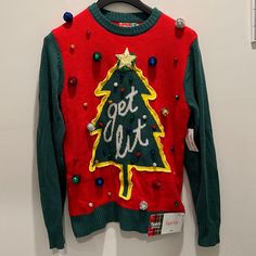 a red and green sweater with a christmas tree on the front that says get out