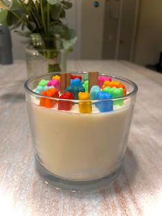 a glass bowl filled with gummy bears on top of a table