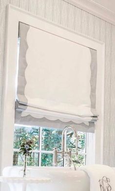 a white sink sitting under a window in a bathroom