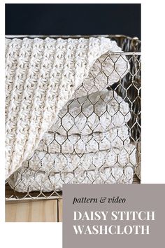 a white crocheted dish cloth sitting on top of a wooden table next to a wire basket