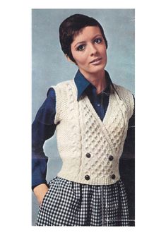 a woman wearing a sweater vest and plaid skirt, with her hands on her hips