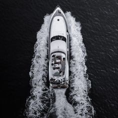 an aerial view of a motor boat in the middle of the ocean with water behind it