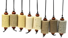 several different types of soaps hanging from strings with wooden bead ends on white background