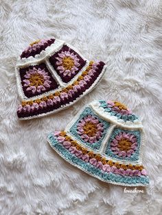 two crocheted hats laying on top of a white furnishing covered floor