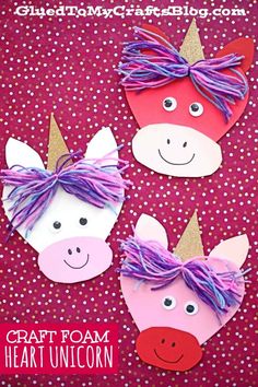 three unicorns made out of paper with purple hair and pink noses on them, sitting next to each other