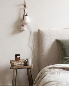 a bedroom with a bed, side table and lamp on the wall next to it