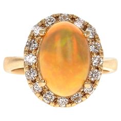 This ring has a cute and simple 2.88 Carat Opal and has a Halo of 16 Round Cut Diamonds that weigh 0.55 Carats (Clarity: VS2, Color: H). The total carat weight of the ring is 3.43 Carats. The Opal displays beautiful flashes of green, yellow, and orange and has its origins from Australia. The ring is curated in 14 Karat Yellow Gold and has an approximate weight of 5.0 grams. It is a size 7 and can be re-sized free of charge. Diamond Gold Ring, Anniversary Gift For Wife, Opal Ring Gold, Vs2 Diamond, Gold Statement Ring, Anniversary Gifts For Wife, Diamonds And Gold, Diamond Gold, Pretty Rings