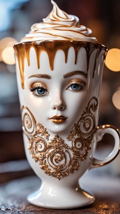 a white cup with gold designs on it and a woman's face in the middle