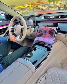 a man sitting in the driver's seat of a car using a laptop computer