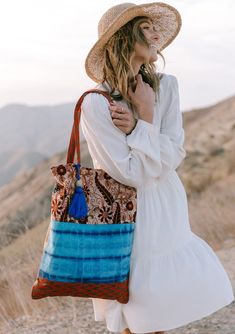 A show-stopping statement bag inspired by some of our favorite vintage designs. Our tie dye patchwork tote bag features a large tassel accent and a snap closure. FINAL SALE Mixed media patchwork Tie-dye Paisley Snap closure Large tassel accent Dimensions: 15" x 20"Style: DR-2105-2 Travel Cotton Bag With Patchwork, Cotton Patchwork Bag For Travel, Patchwork Cotton Travel Bag, Cotton Patchwork Travel Bag, Beach Tote Bag With Patchwork, Brown Cotton Bags For Vacation, Beach Patchwork Tote Bag, Brown Cotton Vacation Bag, Blue Bohemian Tote Canvas Bag