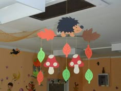 some paper decorations hanging from the ceiling in a room with children's artwork on the walls