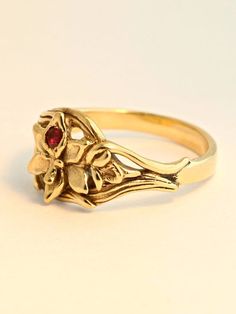 This detailed Orchid Ring is cast in solid 14K gold. A 2.5mm ruby is set in the center of the flower and the leaves of the orchid flow around the finger to form the band. It is 1/3 of an inch wide and rests flat against the finger. We will contact you to let you know if we have your chosen ring size in stock or when to expect shipment. All Marty Magic Jewelry is packaged in a beautiful ring box embossed with the gold foil Marty Magic dragon logo. Perfect for any occasion! Designed in Santa Cruz, 14k Gold Flower Shaped Gemstone Rings, 14k Gold Hallmarked Flower Promise Ring, Heirloom 14k Gold Hallmarked Flower Ring, Flower-shaped Yellow Gold Ruby Ring For Wedding, Flower Shaped Ruby Ring In Yellow Gold For Wedding, Yellow Gold Flower Ruby Ring For Wedding, Yellow Gold Birthstone Flower Ring, Yellow Gold Ruby Ring For Wedding With Flower Shape, Heirloom 14k Gold Flower Ring With Gemstone