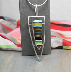 Surf's Up Pendant Indulge your sense of fashion adventure with this bold Surfite pendant!  Dramatic in both color and shape this pendant makes a bold modern art jewelry statement. Surfite is a by product from the manufacturing of surf boards.  It consists of polyester resin and layers of colors that are the waste or left over material.   When cut, shaped and polished by an experienced lapidary Surfite can be transformed into beautiful cabochons suitable for earrings,  rings, pendants and other j Silver Aesthetic Jewelry, Silver Statement Jewelry, Surf Boards, Polyester Resin, Fused Glass Jewelry, Adventure Style, Silver Snake Chain, Jewelry Statement, Surfs Up