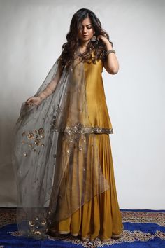 Burnt gold and grey kurta in dupion silk base. Comes with georgette sharara and an organza dupatta having dual coloured patchwork, including zari and sequins hand embroidered chakra motifs.
Component: 3
Pattern: Embroidered
Type Of Work: Zari, Sequins
Neckline: V Neck
Sleeve Type: Short
Fabric: Kurta : Dupion Silk, Sharara : Georgette, Dupatta : Organza 
Color: Gold
Other Details: 
Embroidered neckline and borders on kurta
Closure : Sharara : Fixed belt at front and elastic at cack, Opening on t Silk Sharara, Grey Kurta, Georgette Sharara, Georgette Dupatta, Pakistani Dresses Casual, Pakistani Fashion Party Wear, Indian Dresses Traditional, Beautiful Pakistani Dresses, Salwar Kamiz